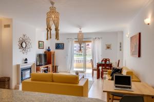 een woonkamer met een bank en een tafel met een laptop bij Casa da Praia in Ericeira