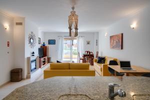 a living room with a yellow couch and a table at Casa da Praia in Ericeira