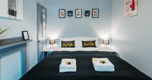 a bedroom with a bed with two towels on it at The Clifford Gathering York - Sleeps Up To 10 in York