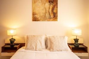 een slaapkamer met een bed met twee lampen en een schilderij bij Casa da Praia in Ericeira +42 foto's