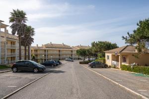 een straat met auto's geparkeerd voor een gebouw bij Casa da Praia in Ericeira