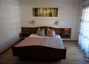 a bedroom with a large bed with pink pillows at Gasthof Zum Löwen in Mespelbrunn