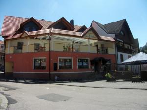 a red and yellow building with a balcony at Gasthof Zum Löwen in Mespelbrunn