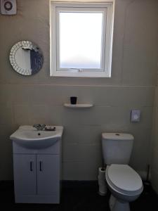 a bathroom with a toilet and a sink and a window at Royal Albion Walton in Walton-on-the-Naze