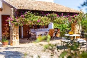 a patio with a table and chairs and flowers at Son Mulet in Llubí