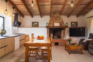 a kitchen and living room with a table and a fireplace at Vinagrella in Llubí