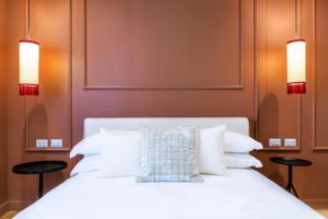 a bedroom with a white bed with two stools at The Couper Colonna in Rome