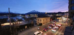 a city with cars parked on a street at night at Belle Epoque Luzern in Lucerne