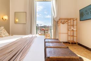 a hotel room with two beds and a large window at Autentica Ortigia in Siracusa