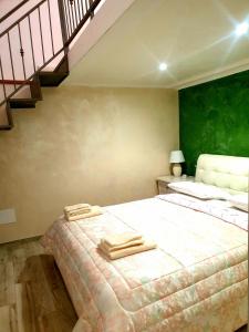 a bedroom with a large bed with a green wall at Apartment Mary in Terracina