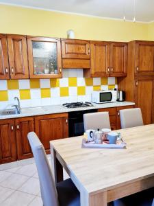 una cocina con una mesa de madera con sillas y un asterisco en Casa Colonna, en Montegrotto Terme