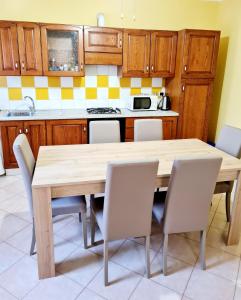 cocina con mesa de madera y sillas en Casa Colonna, en Montegrotto Terme