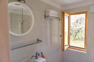 a bathroom with a sink and a mirror and a window at Zöld Sziget Vendégház in Balatonkenese