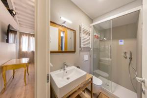 a white bathroom with a sink and a shower at Élite Home stunning venetian apt. Close Accademia in Venice