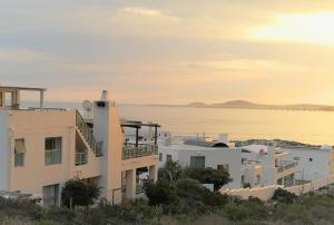 a building on a hill next to a body of water at Langebaan Paradise Beach 9 Elara in Langebaan