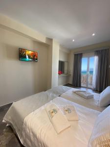 una camera d'albergo con due letti e asciugamani di MIKE'S STUDIOS a Sidari