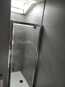 a shower with a glass door in a bathroom at Town Centre House with parking in Cheltenham