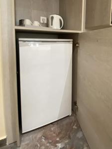a white refrigerator in a kitchen with a shelf at MIKE'S STUDIOS in Sidari