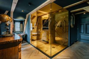 uma grande cabina de duche em vidro numa casa de banho com paredes azuis em Boutique Hotel The Noblemen em Amsterdã