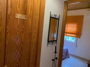 a room with a wooden door and a mirror at Can Marcela in Deltebre