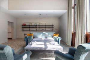 een woonkamer met een bed en 2 stoelen bij Infinite House Ca' Vendramin in Venetië