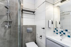 een badkamer met een douche, een toilet en een wastafel bij Zamkowe Apartamenty in Sandomierz