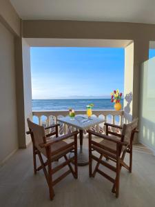 - une table et des chaises dans une chambre avec vue sur l'océan dans l'établissement MIKE'S STUDIOS, à Sidari