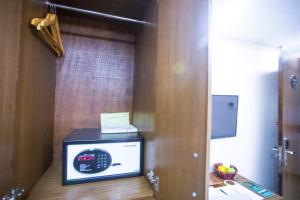 a microwave sitting on top of a wooden shelf at Hotel 71 in Dhaka