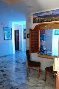 Zimmer mit einem Stuhl, einem Tisch und einem Fenster in der Unterkunft Bed & Breakfast Il Golfo in Neapel