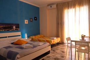a bedroom with two beds and a table and a window at Bed & Breakfast Il Golfo in Naples