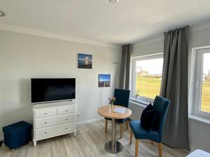 a living room with a tv and a table and chairs at Meeresrauschen in Dahme