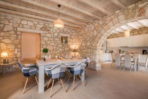 a large kitchen and dining room with a stone wall at Ionio Villa Elia in Vasilikos