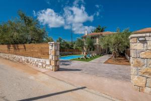 a stone retaining wall in front of a house at Ionio Villa Elia in Vasilikos