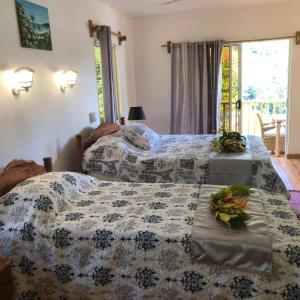 um quarto com duas camas com flores em Ocean View Apartment em Praslin