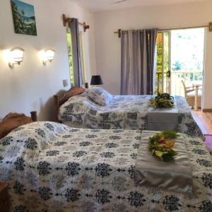 a bedroom with two beds with flowers on them at Ocean View Apartment in Praslin +13 photos