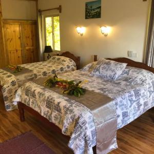 two beds in a bedroom with flowers on them at Ocean View Apartment in Anse Possession