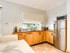 a kitchen with wooden cabinets and a stainless steel refrigerator at Mazursko - Apartamenty in Kretowiny