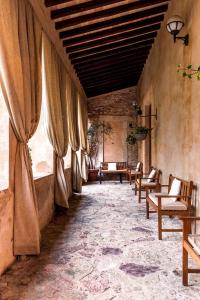 Ex Convento Santa Croce-Country resort في SantʼAnatolia di Narco: غرفة مع كراسي وطاولات في مبنى