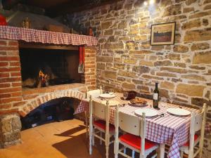 a dining room with a table and a fireplace at Casa Leonarda, old authentic Istrian stone house near Motovun, central Istria in Zamask