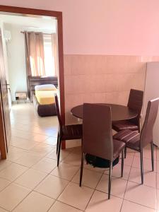ein Esszimmer mit einem Tisch und Stühlen sowie ein Schlafzimmer in der Unterkunft Guest House Ondine in Shëngjin
