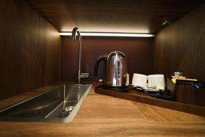 a kitchen with a sink and a coffee pot on a counter at Mimi's Hotel Soho in London