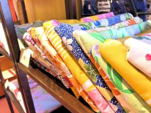 a row of colorful fabrics on display in a store at Kinokuniya Ryokan in Hakone