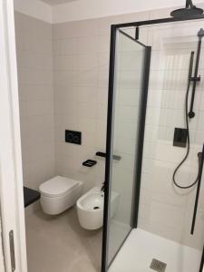 a bathroom with a toilet and a glass shower stall at Petit Porto Cervo in Porto Cervo