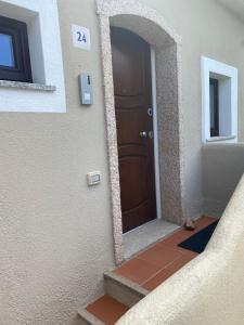 a door to a building with a cat sitting in front of it at Petit Porto Cervo in Porto Cervo