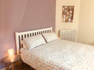 1 dormitorio con 1 cama y 1 vela sobre una mesa en 4 Balvaig Cottage en Stirling