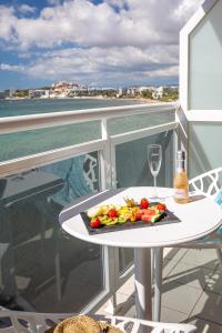 a plate of food and a wine glass on a table on a balcony at Hotel Ses Figueres in Talamanca