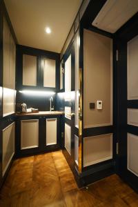 a kitchen with black cabinets and a sink and a door at Mimi's Hotel Soho in London