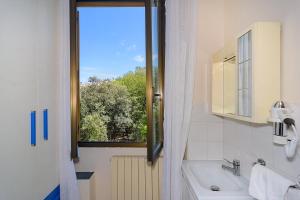ヴィアレッジョにあるVilla Graziaの窓、バスタブ、シンク付きのバスルーム