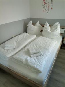 a bed with white sheets and pillows on it at Ferienwohnung Bergwichtel Hahnenklee "super Aussicht" in Hahnenklee-Bockswiese