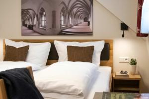 a bedroom with two beds and a picture on the wall at Klostergasthof Heidenheim - Hotel Garni in Heidenheim